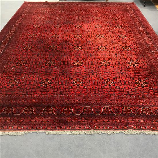 An Afghan red ground carpet 395cm x 300cm